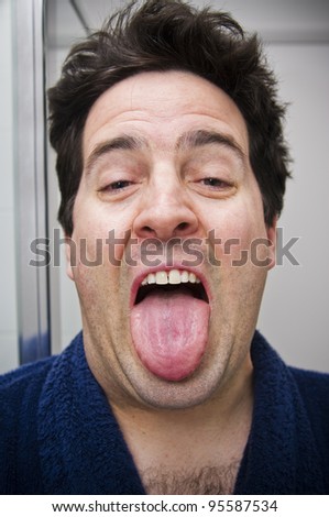 A stock photo of a man who has just woken up looking in the mirror