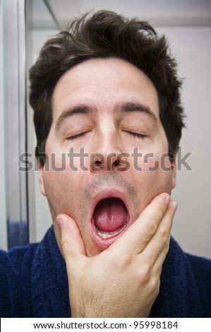 A stock photo of a man who has just woken up yawning