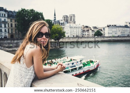 Beautiful young woman in Paris on holidays in France staying near Seine river while walking on Champs-Elysees, Paris, France