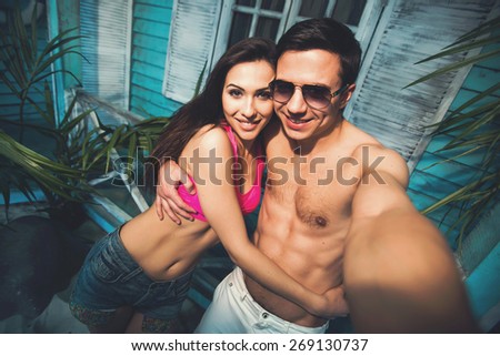 Beautiful couple in love relaxing and doing selfie self-portrait while spending holidays in beach house at ocean