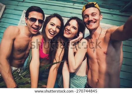 Multiracial group of friends taking selfie self-portrait at beach house at seaside