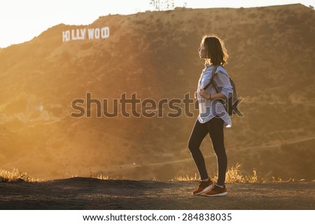 HOLLYWOOD CALIFORNIA - MAY 1: A teenage girl tourist hiking at Hollywood Hills near world famous landmark Hollywood Sign on May 1, 2015 in Los Angeles, California.