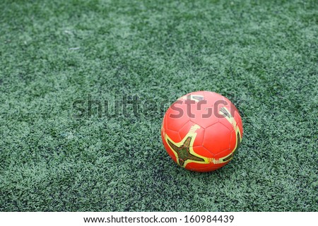 The orange football on green grass