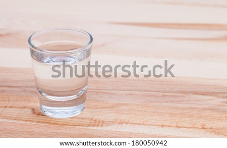 Clear drink on wood table.