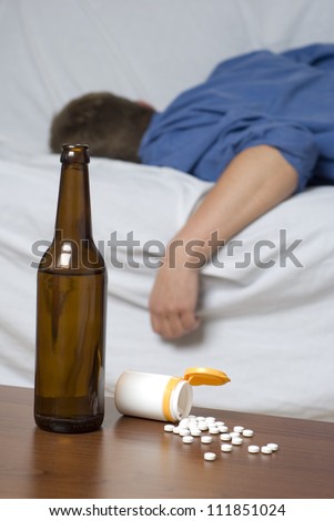 Businessman passed out on the bed after long day of work. Mixed alcohol and drug abuse.