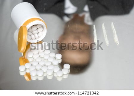 Drugs on a mirror. Steady and out of focus reflection of a businessman.