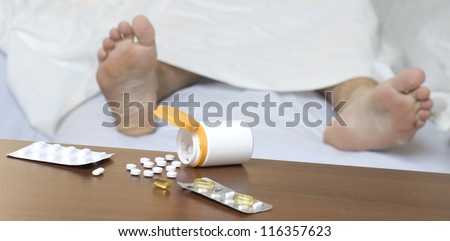 Different pills on the table. Person sleeping in the background. Impalanced diagonal composition