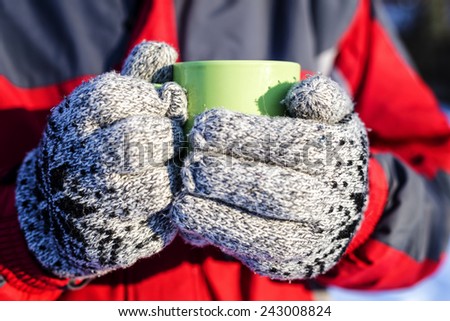 Closeup of man hands holding a cup of hot drink outdoor