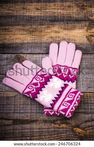Closeup of knitted winter gloves isolated on wooden board