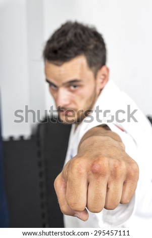 Closeup of young karate man throwing a punch during his training at the gym