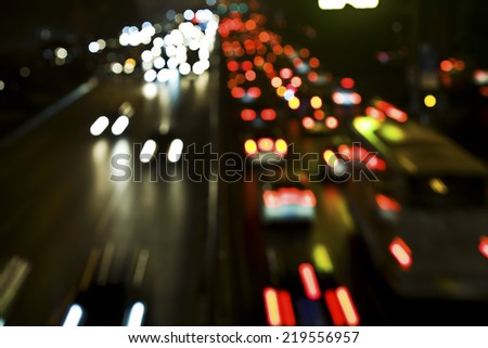 Blurred Defocused Lights of Heavy Traffic on a Wet Rainy City Road at Night - Commuting at Rush Hour Concept