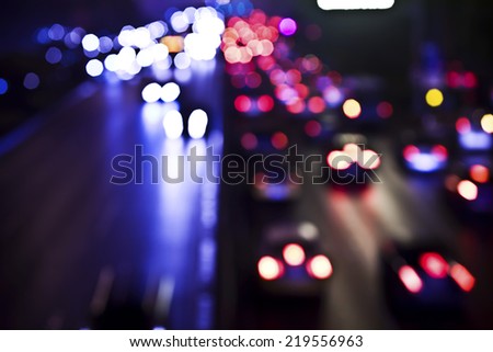 Blurred Defocused Lights of Heavy Traffic on a Wet Rainy City Road at Night - Commuting at Rush Hour Concept