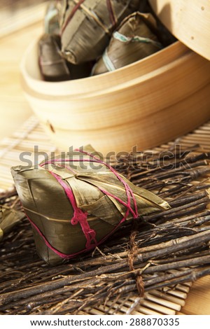 Asian Chinese rice dumplings on basket, tea at background.