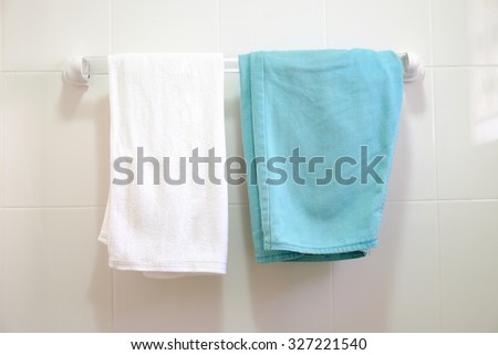 White towel. With green shorts. On the white wall