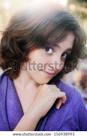 Closeup sunset portrait of a teenage girl with cute look in back lighting