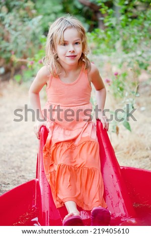 Adorable little girl half-soaked in a small house backyard pool