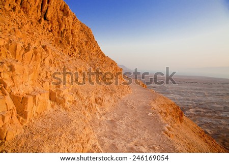 Dangerous path on the mountain slope in Negev desert at sunset