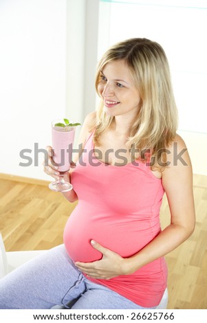 young pretty sexily pregnant woman drinks milk shake