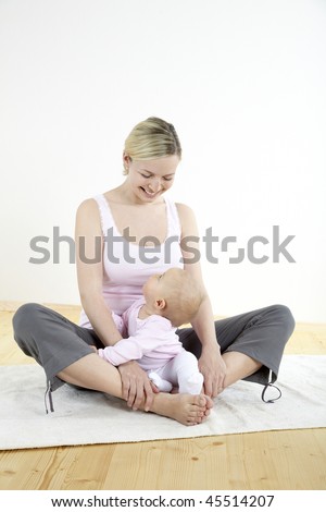 a young mother does physical fitness exercises together with her baby