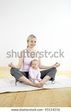 a young mother does physical fitness exercises together with her baby
