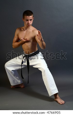 Young sporty karate man doing special exercise
