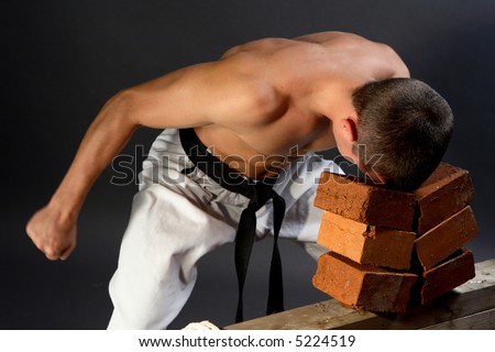 stock-photo-young-sporty-karate-man-breaking-three-bricks-on-gray-background-5224519.jpg