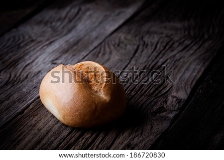 Delicious fresh baked roll. Bakery product photography taken on old wooden table.