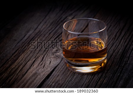 Glass of luxury single malt whiskey. Drink concept photography taken on old wooden table.