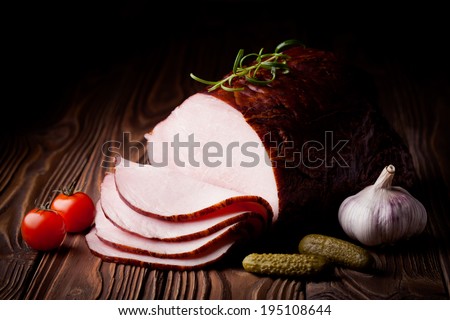 Fresh polish smoked ham slices. Meat composition taken on rustic wooden table.