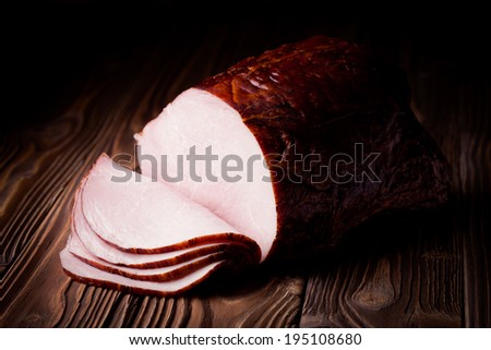 Fresh polish smoked ham slices. Meat composition taken on rustic wooden table.