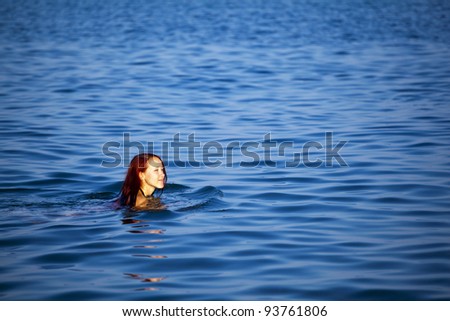 Beautiful young woman swimming in sea. Rhodes during summer.