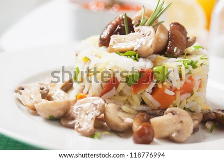 Cooked rice, risotto with vegetables and button mushrooms