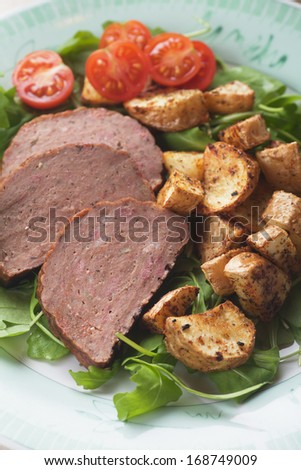 Meat loaf with roasted potato, lettuce and cherry tomato