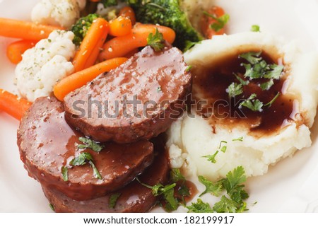 Meat loaf slices with mashed potato and cooked vegetables
