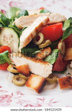 Chicken salad with olives, tomato, croutons, and corn-salad