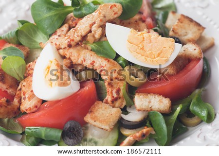 Chicken salad with olives, tomato, croutons, and corn salad