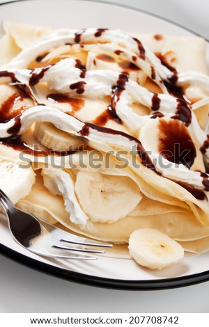 Crepes with banana slices and chocolate topping