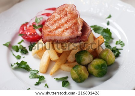 Grilled ham slices with brussel sprout and french fries