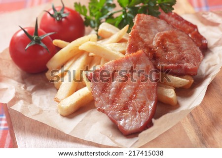 Grilled ham slices with cherry tomato and french fries