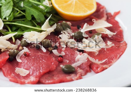 Beef carpaccio with parmesan cheese, capers and rocket salad