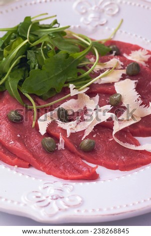 Beef carpaccio with parmesan cheese, capers and rocket salad