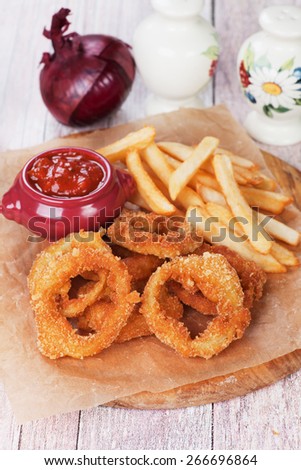 Deep fried crispy onion rings with french fries and salsa dip