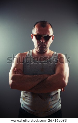 Strong, hard working man, studio portrait of middle aged man in worn shirt