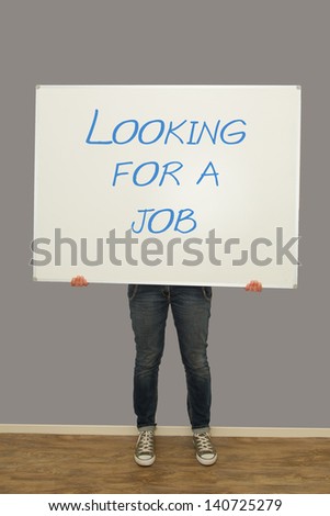 Woman holding a big whiteboard with looking for a job written on it