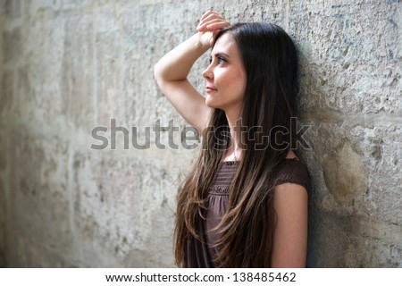 Girl leaning against a wall