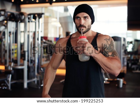 Muscular man drinking water