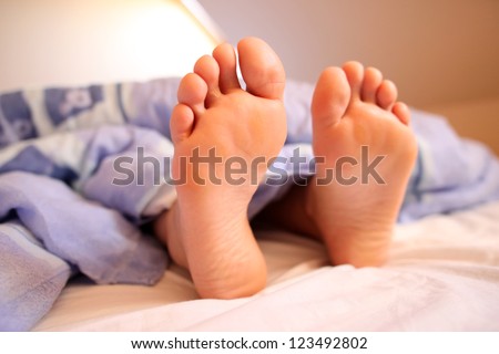 Young woman bare feet in bed