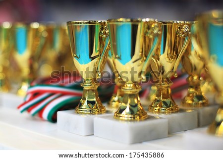 Many golden trophy on table