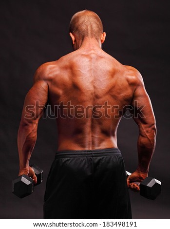 Back of muscular male bodybuilder with dumbbell