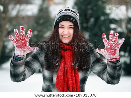 Young beautiful woman showing stop her snowy palm in winter